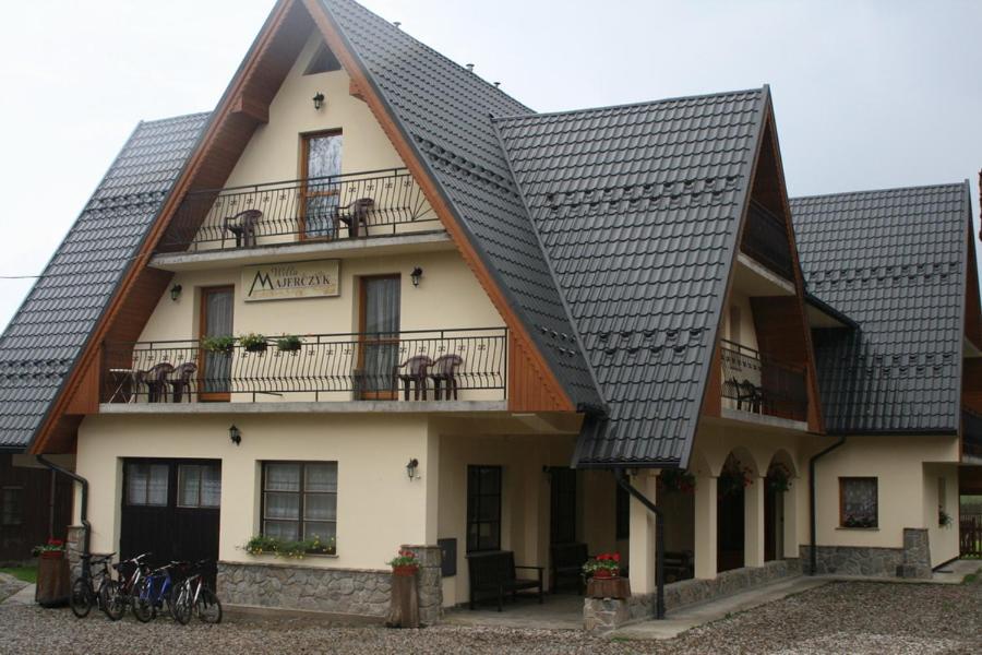 una casa con techo negro y balcón con bicicletas en Willa Majerczyk, en Zakopane