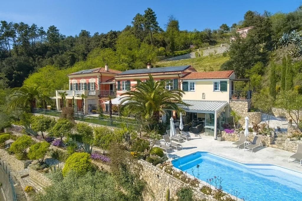 a house with a swimming pool next to a mountain at Villa Amaranta in La Spezia