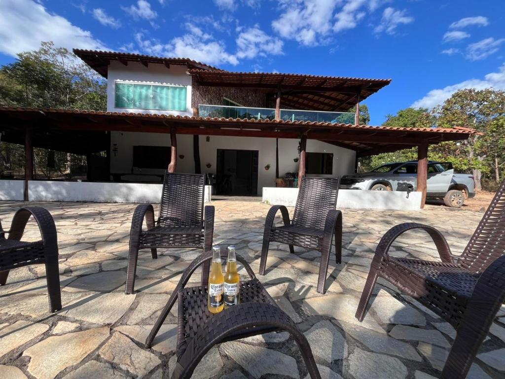 eine Terrasse mit Stühlen und einem Tisch mit Getränken darauf in der Unterkunft Casa com piscina em São Jorge Go in Alto Paraíso de Goiás