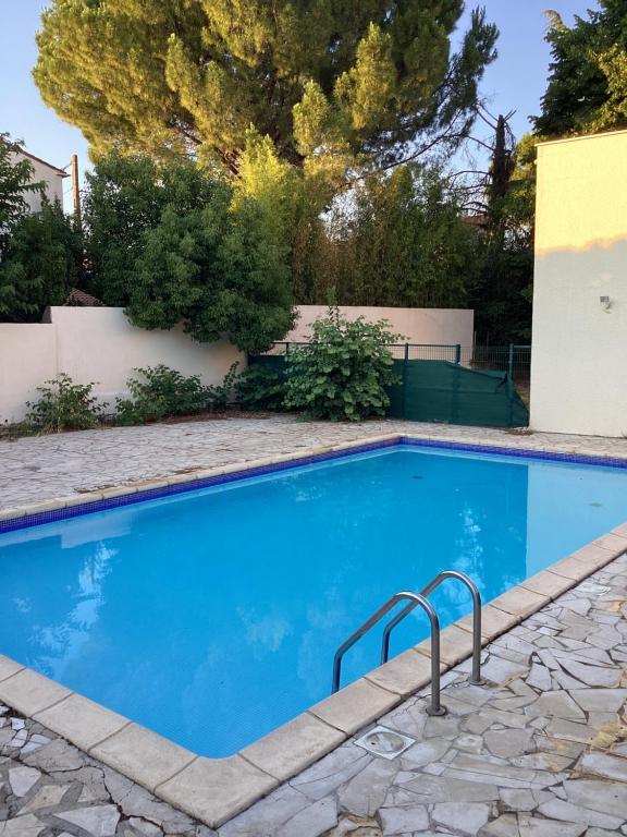 une piscine avec de l'eau bleue dans une cour dans l'établissement Beau studio, à Nîmes