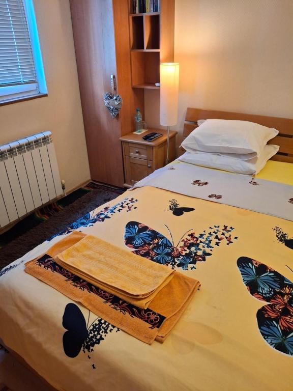 a bed with a blanket with butterflies on it at Stay with Me bed and breakfast, parking, pets welcom in Sofia