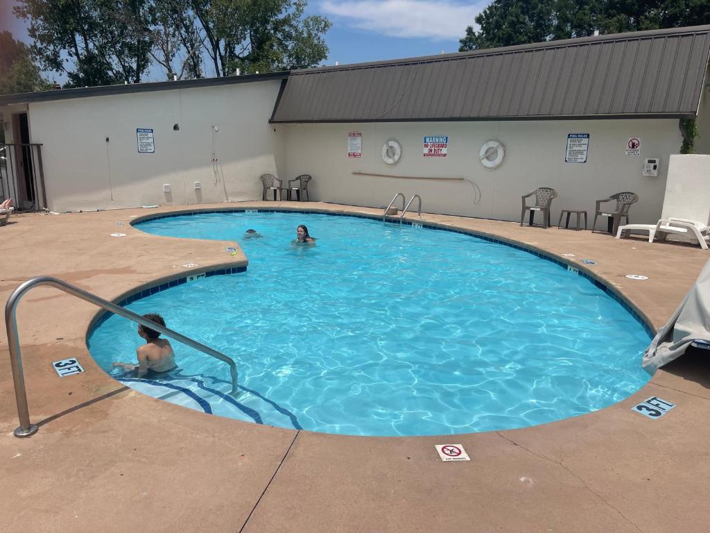 two people swimming in a large swimming pool at Super 8 by Wyndham Monroe in Monroe
