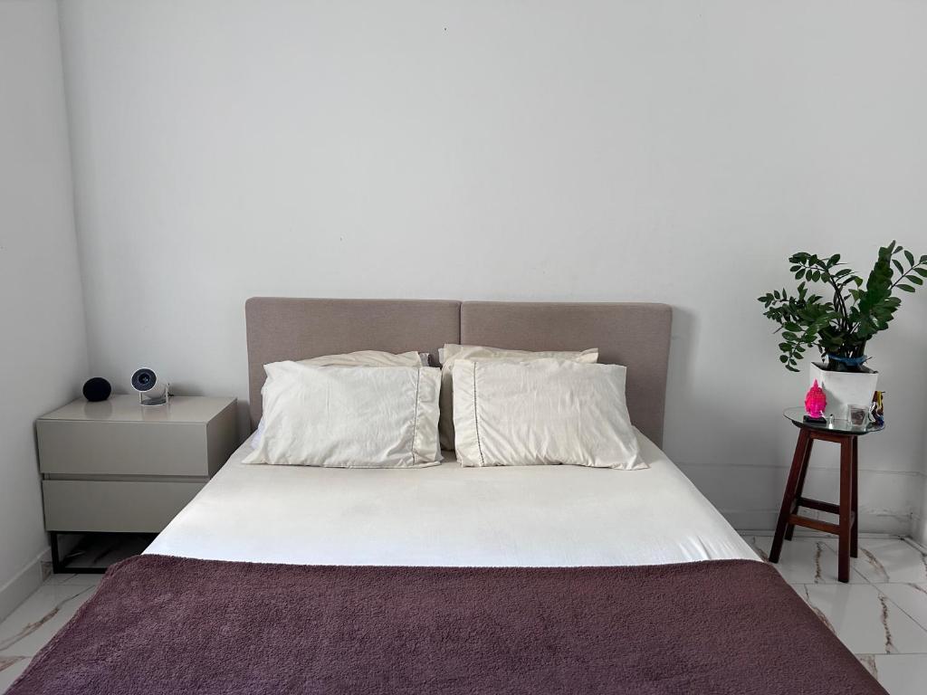 a bed with white sheets and pillows in a bedroom at Residência Ruiz in Sao Paulo