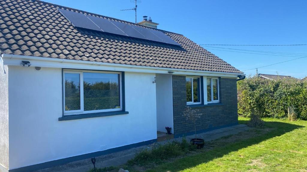 a house with a solar panel on the roof at Namah Stay in Courtown