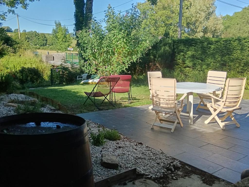 d'une terrasse avec une table, des chaises et un foyer extérieur. dans l'établissement Le clos des papillons, à Carly