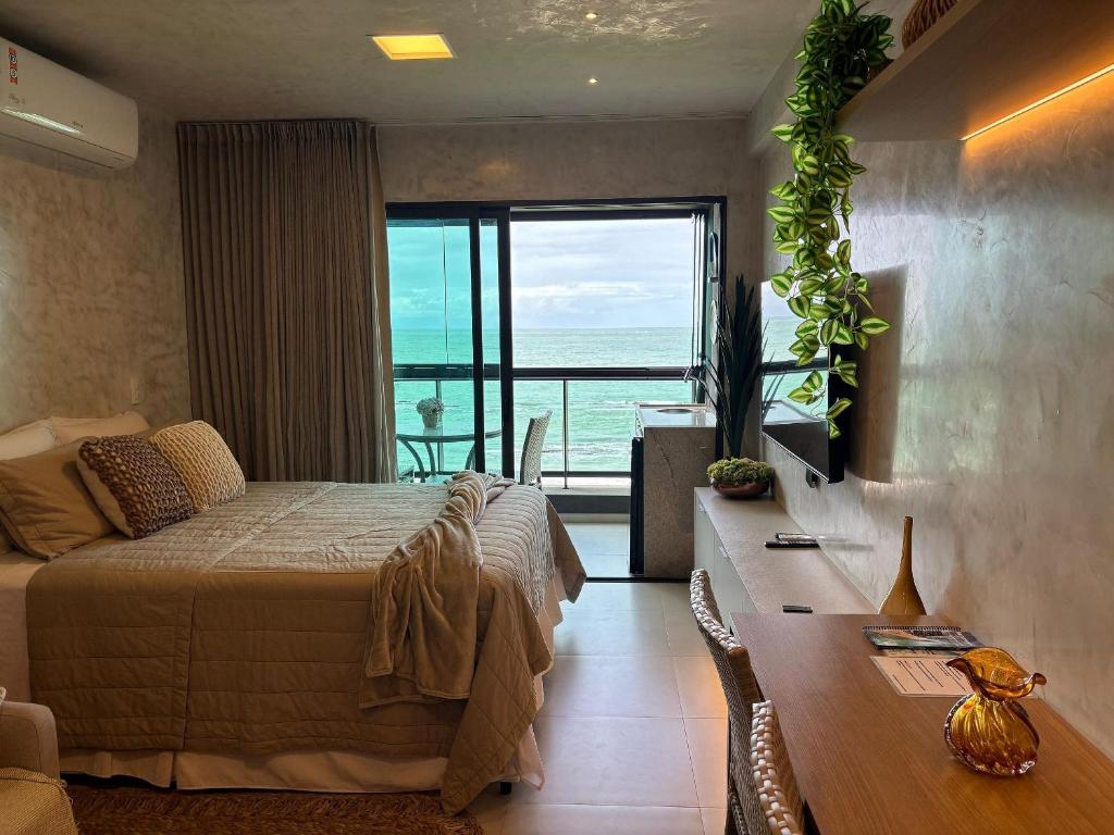 a bedroom with a bed and a view of the ocean at Kauai Beach Residence in Tamandaré
