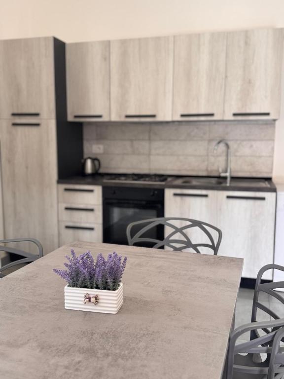 a kitchen with a table with purple flowers on it at Sarno La Vecchia Cascina in Sarno