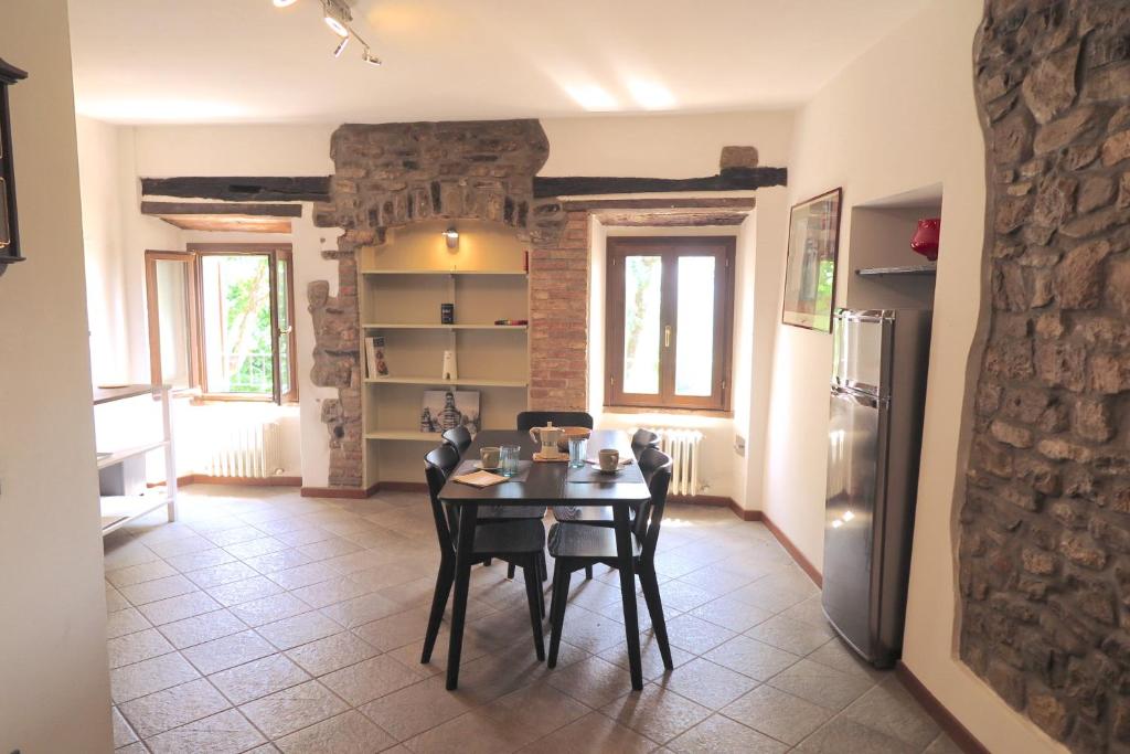 a dining room with a table and a refrigerator at Residenza La Rocca 1227 - Borgo Castello di Serravalle in Castello di Serravalle