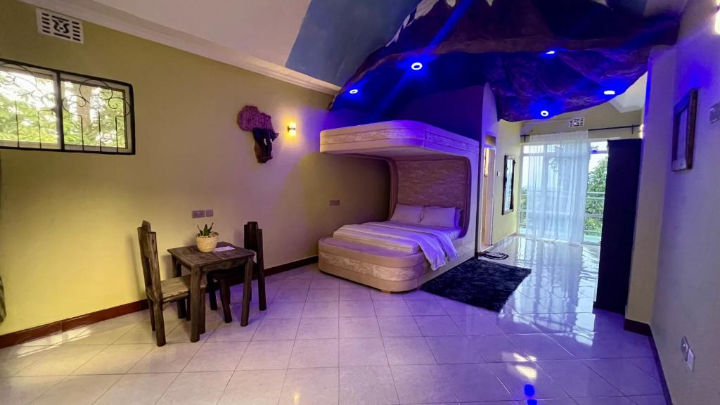 a bedroom with a bed and a table in a room at Skill forest lodge in Arusha