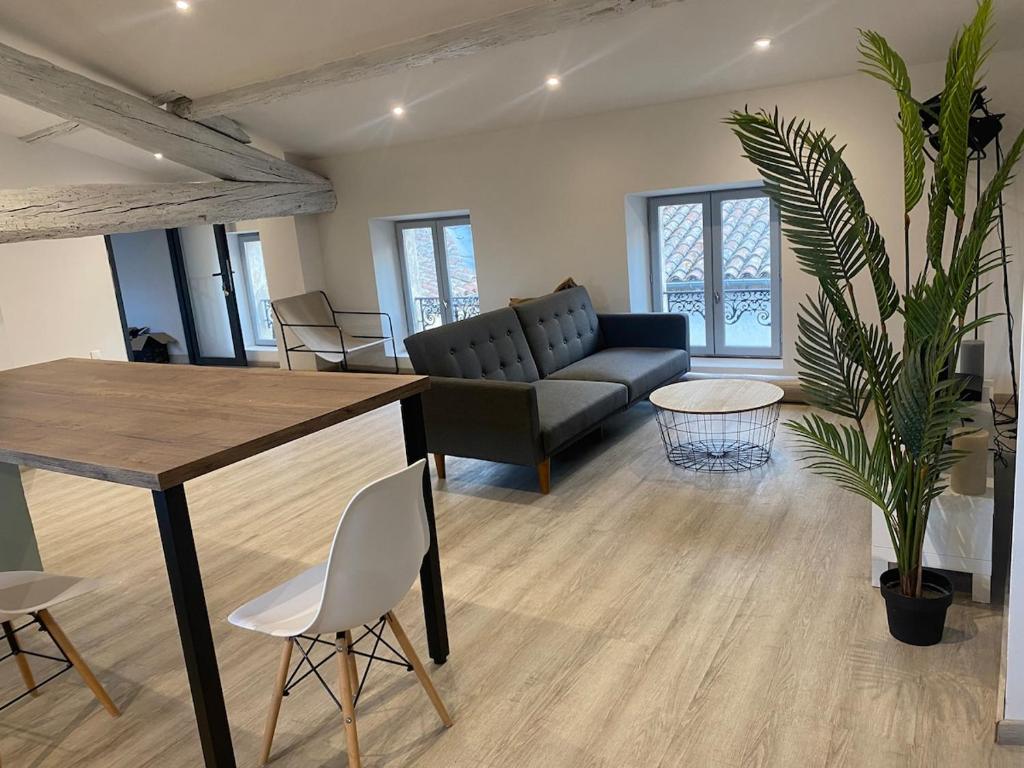 a living room with a couch and a table at Superbe Appartement Atypique Combles - Neuf avec Vue in Narbonne