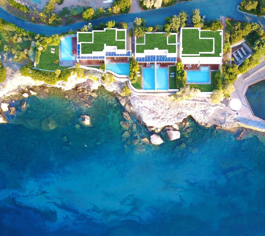 Luftblick auf ein Resort mit blauem Wasser in der Unterkunft Grand Resort Lagonissi in Lagonisi