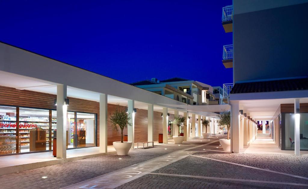 eine Reihe von Gebäuden in der Nacht mit Topfpflanzen in der Unterkunft Verudela Villas in Pula