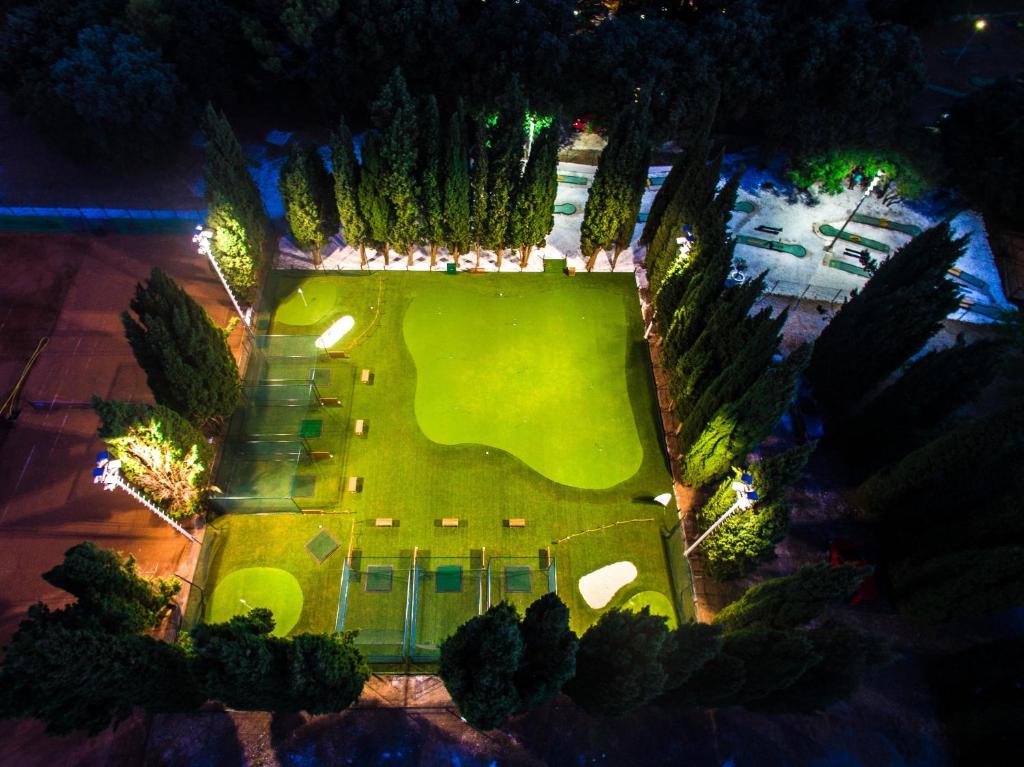 eine Draufsicht auf einen Rasen mit Bäumen und Lichtern in der Unterkunft Verudela Villas in Pula