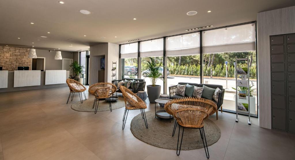 ein Wohnzimmer mit Stühlen, Tischen und Fenstern in der Unterkunft Arena Grand Kazela Camping Homes in Medulin