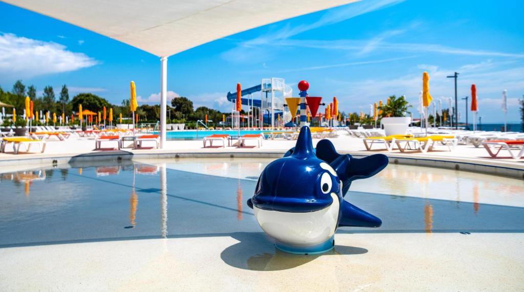 ein Wasserpark mit einem Haispielzeug im Wasser in der Unterkunft Arena Grand Kazela Camping Homes in Medulin