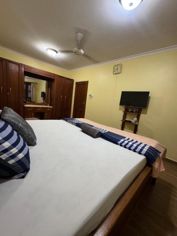 a bedroom with a large bed with blue and white pillows at Sweet dream house in Zanzibar City