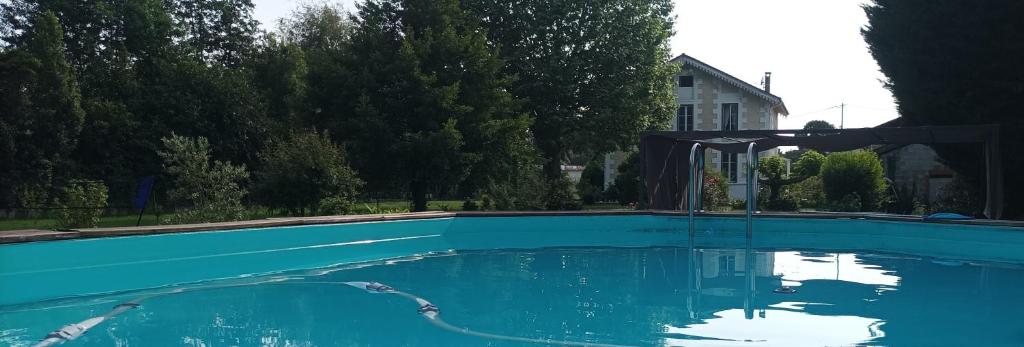 a large pool of blue water with a canopy at Montplaisir in Montendre