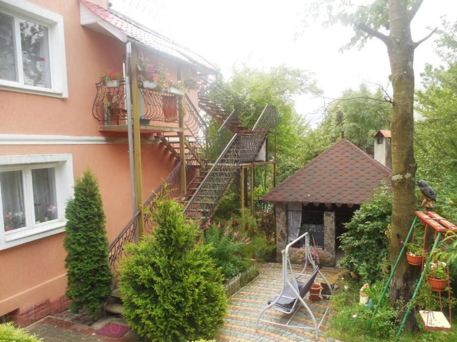 een huis met een trap naast een huis met een tuin bij Apartments and Sauna in Truskavets