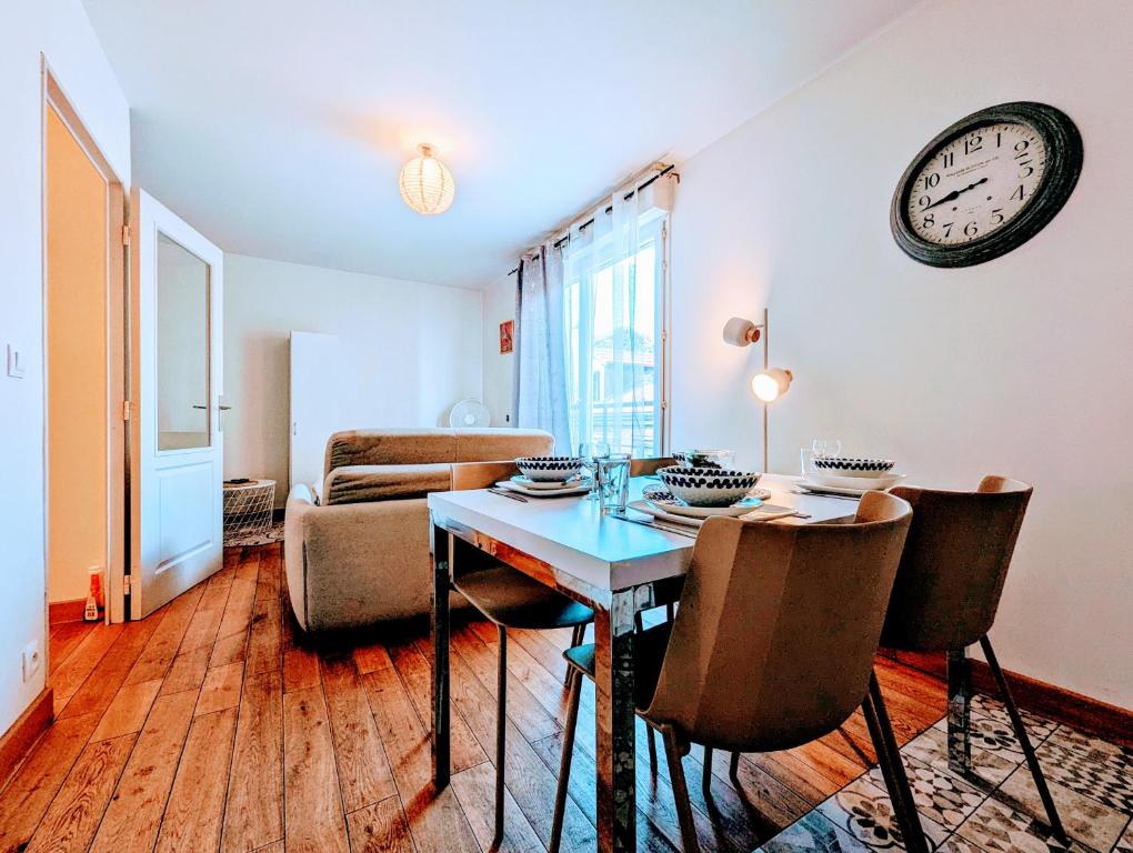 - un salon avec une table et une horloge murale dans l'établissement Budget studio- The river seine, à Saint-Denis