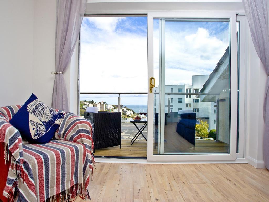 a living room with a couch and a sliding glass door at Sea Salt Lodge in Torquay