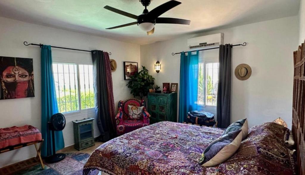 een slaapkamer met een bed en een plafondventilator bij Villa Jina in Torrox