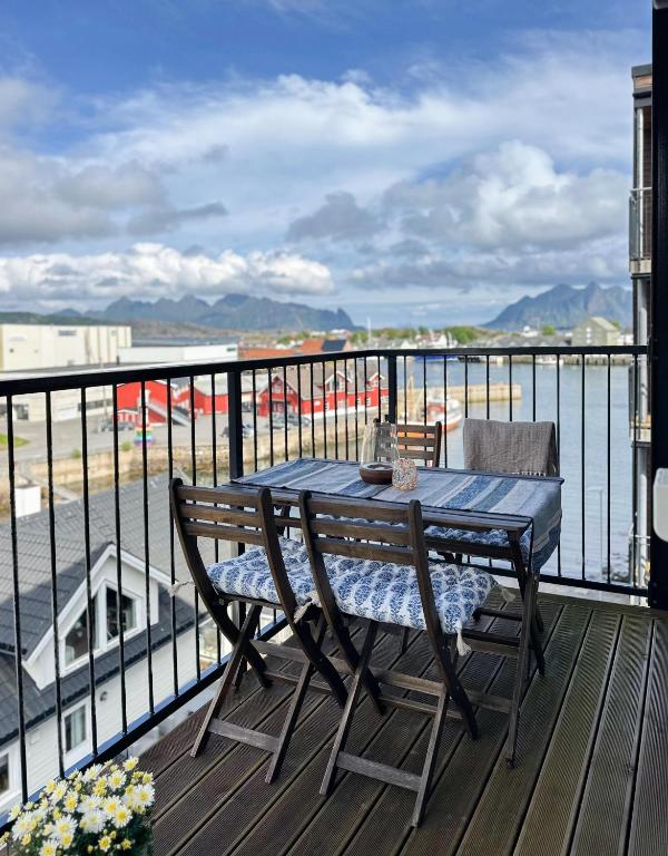 a table and chairs on a balcony with a view of the ocean at Mountain and Sea View Svolvær in Svolvær