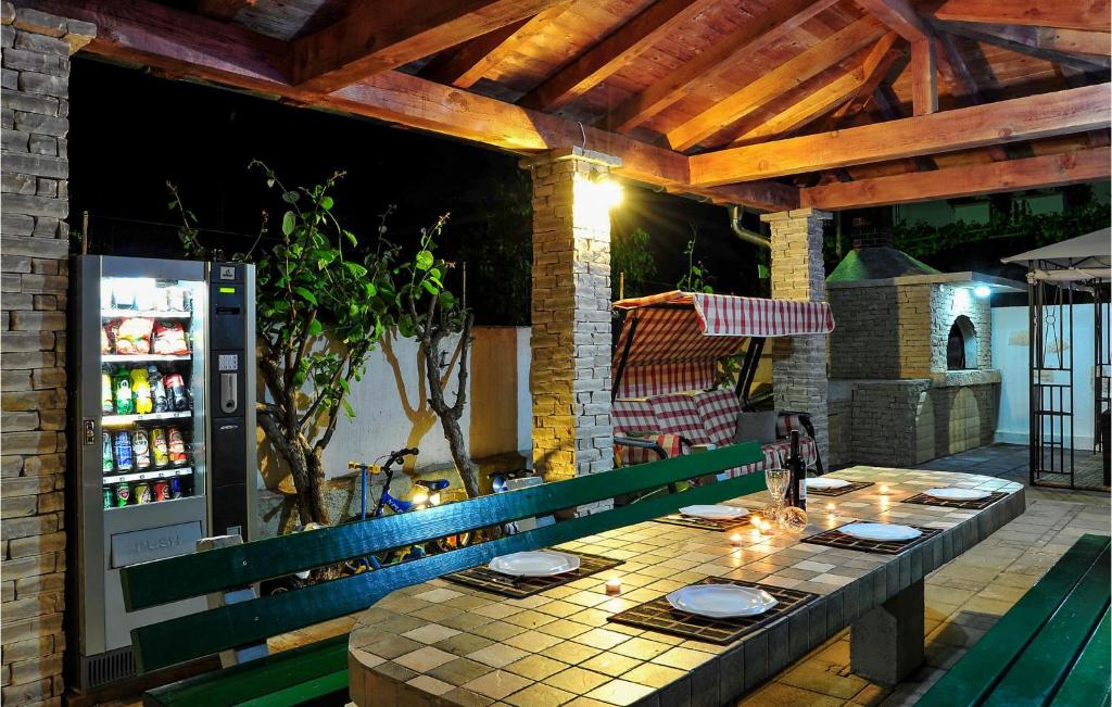 a table on an outdoor patio with a refrigerator at Gorgeous Apartment In Sukosan in Sukošan