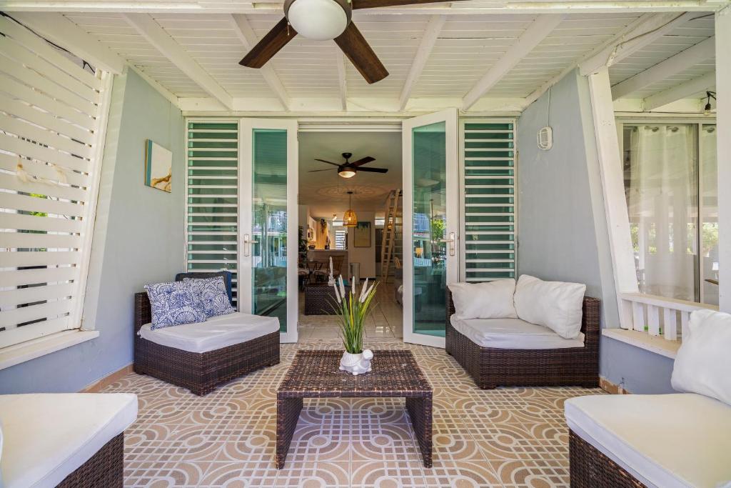 a porch with a couch and chairs and a table at Dorado Del Mar Villa by PH in Dorado