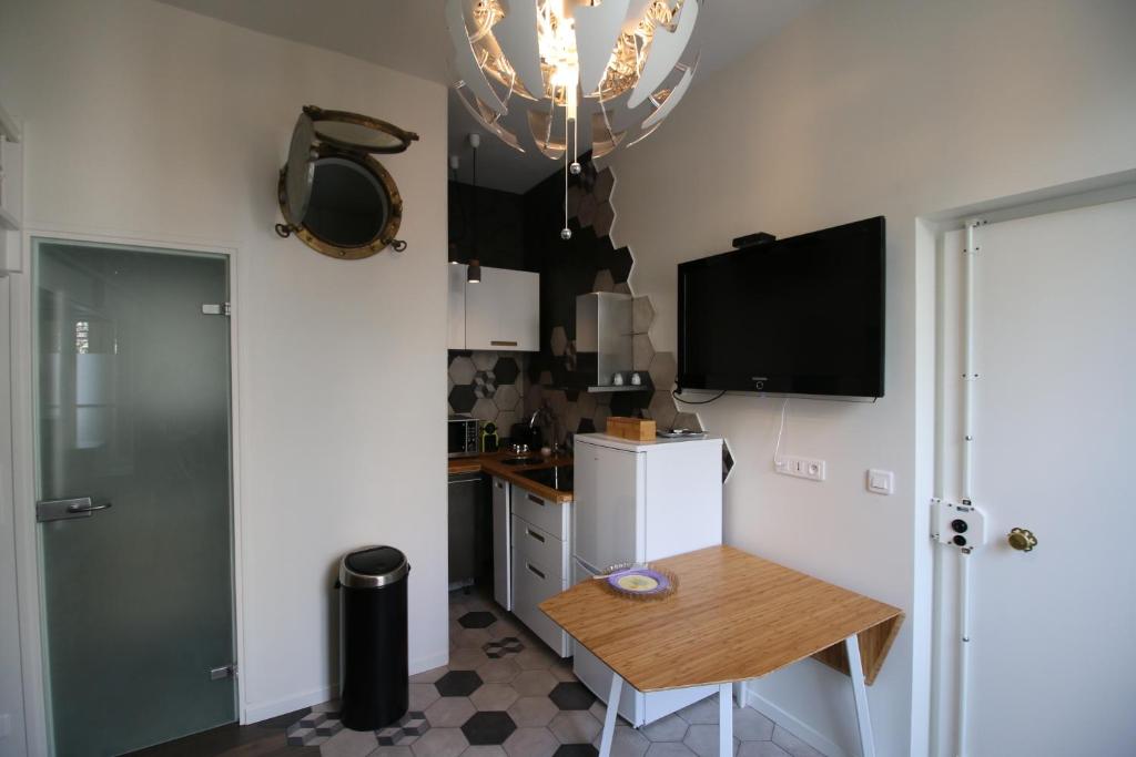 a kitchen with a small table and a refrigerator at Le Petit Lys in Vincennes