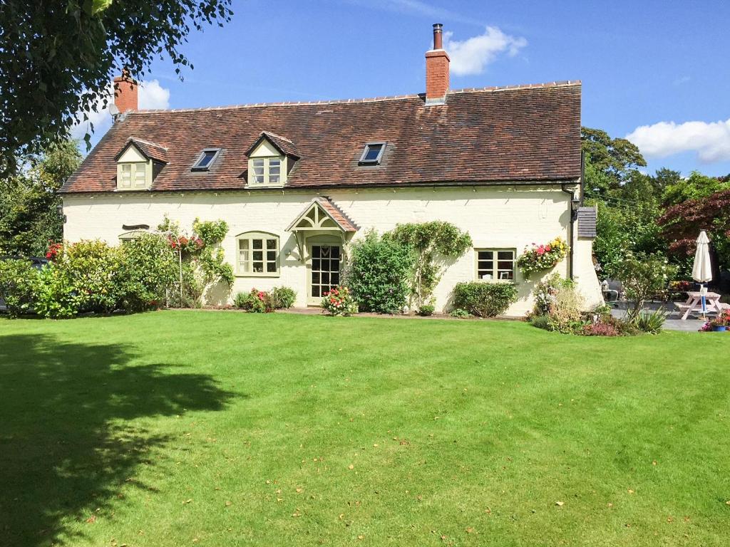 a large white house with a large green yard at Old Church Farm in Hinstock