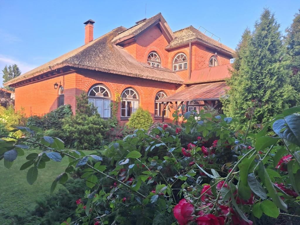 an orange brick house with a garden in front of it at Rent in summer in Ragaciems
