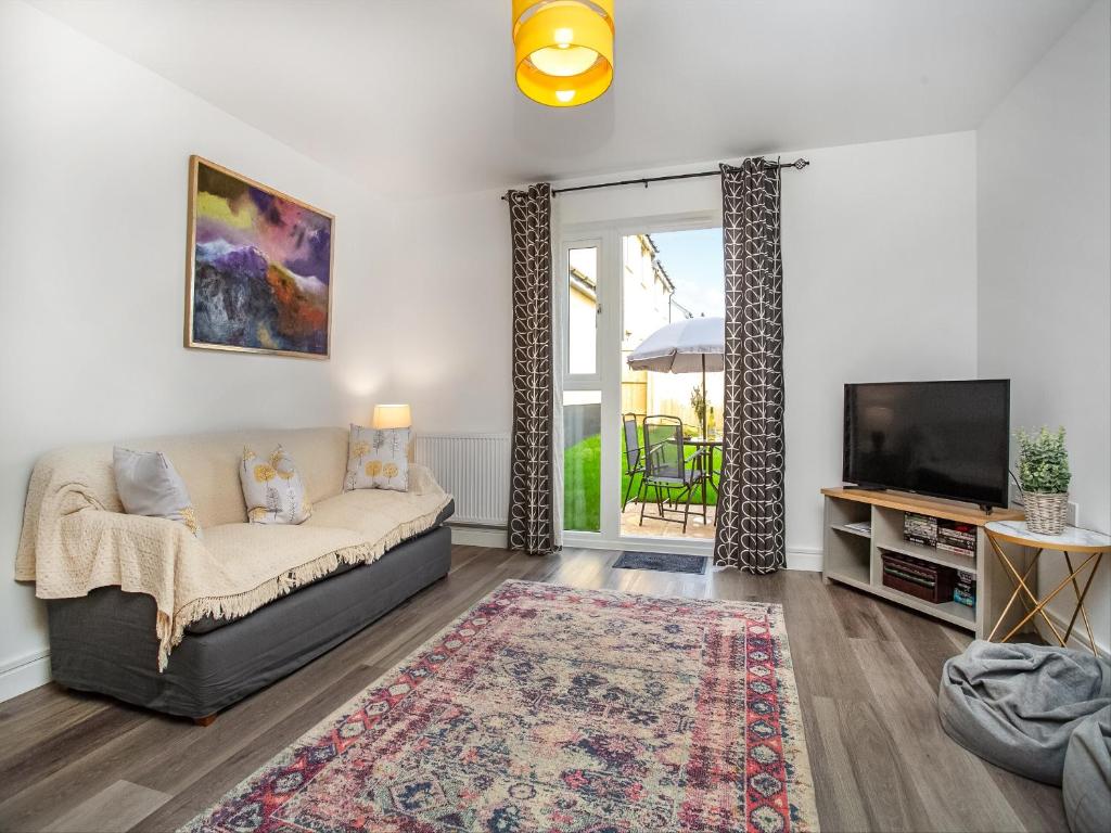 ein Wohnzimmer mit Sofa und Fernseher in der Unterkunft Wagtails in Dartmouth