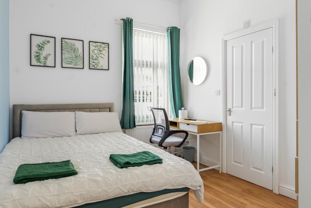 ein Schlafzimmer mit einem Bett, einem Schreibtisch und einem Stuhl in der Unterkunft Newly renovated 3 Ensuite bedroom house in bury, 5 people in Bury