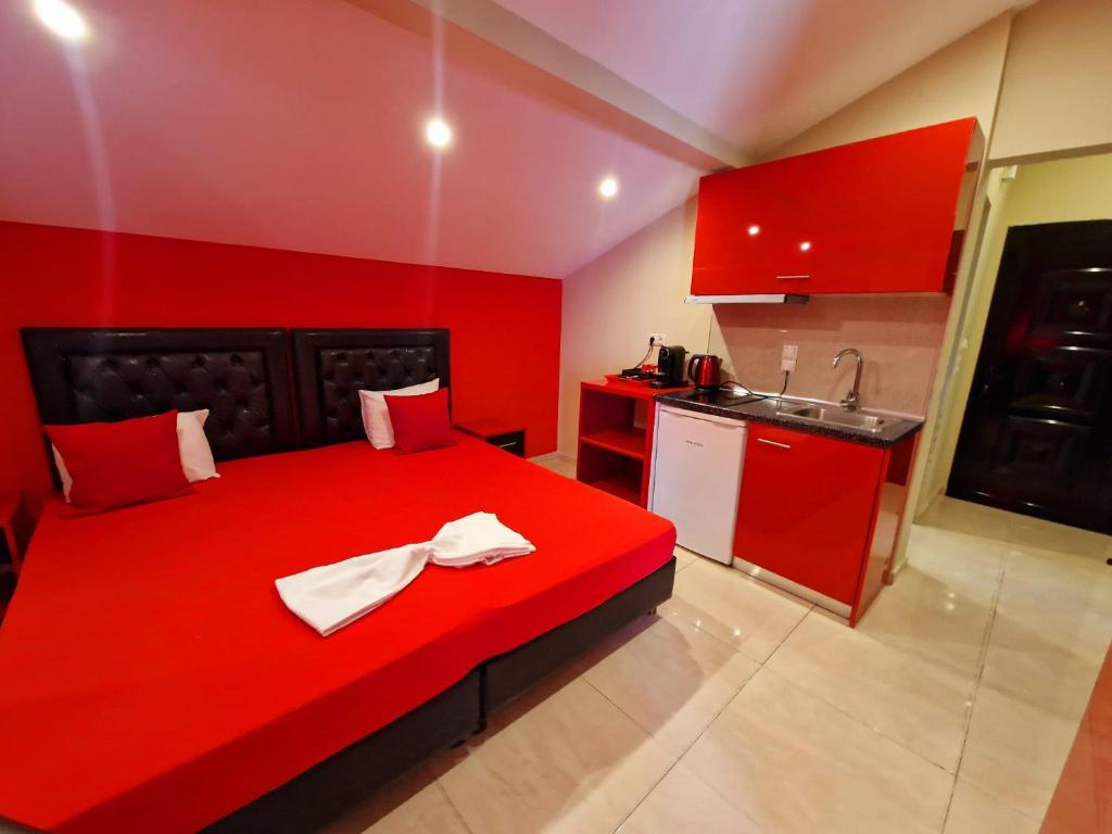 1 cama roja en una habitación pequeña con cocina en Apartmani Vesna Luxury & Stefan ap 4, en Paralia Katerinis