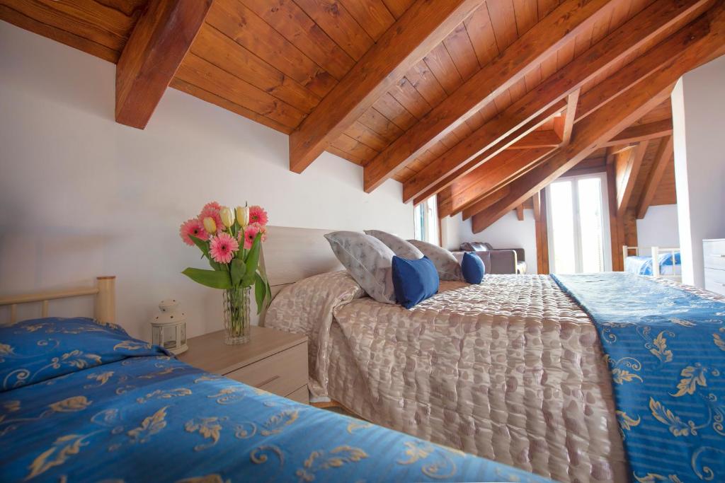 ein Schlafzimmer mit 2 Betten und einer Vase aus Blumen in der Unterkunft Hotel Bristol in Lavagna