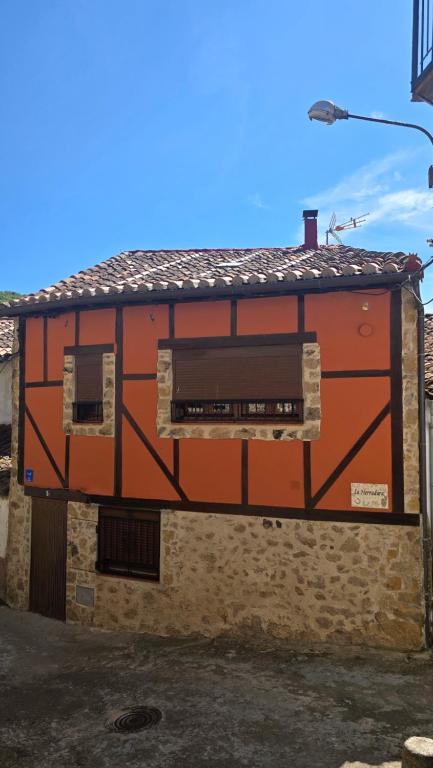 an orange building with a window on the side of it at La herradura, acogedora casa en Montemayor del Río in Montemayor del Río