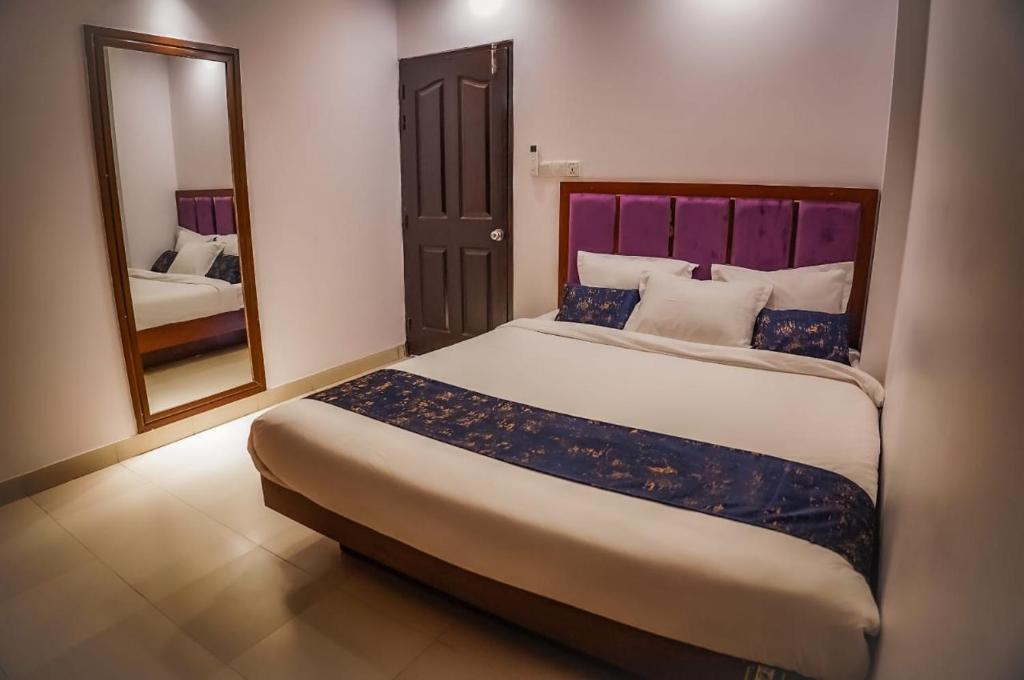 a bedroom with a large bed and a mirror at Needs Bay Watch in Cox's Bazar