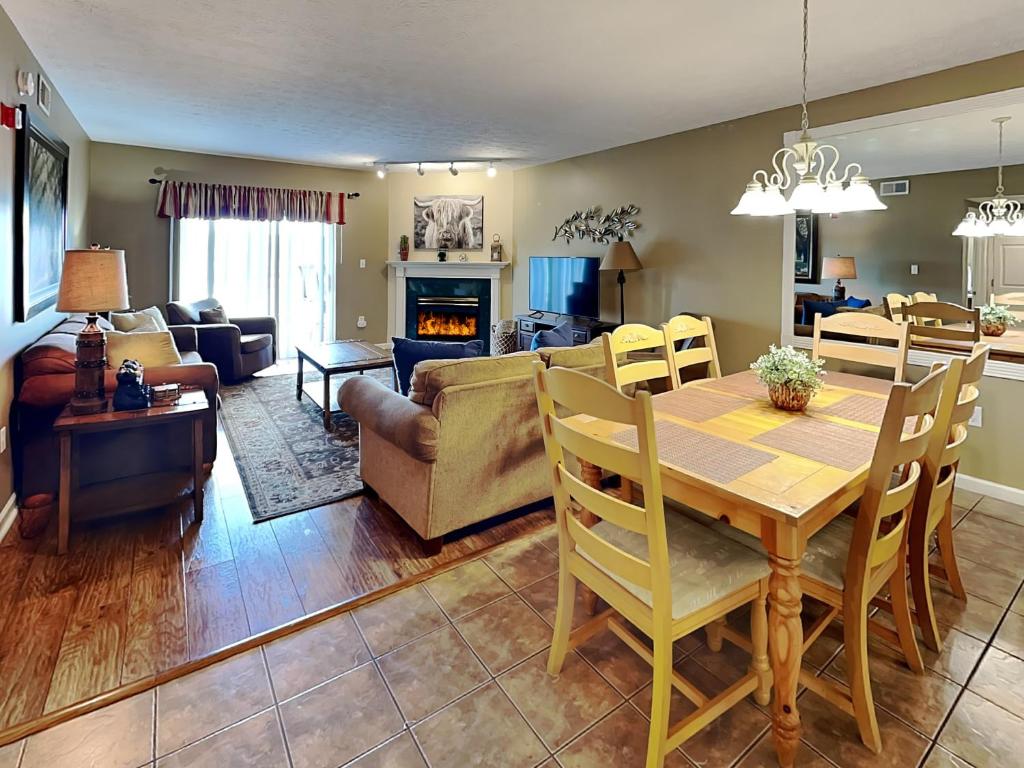 une salle à manger et un salon avec une table et des chaises dans l'établissement Smoky Mountain Memories Whispering Pines 232, à Pigeon Forge