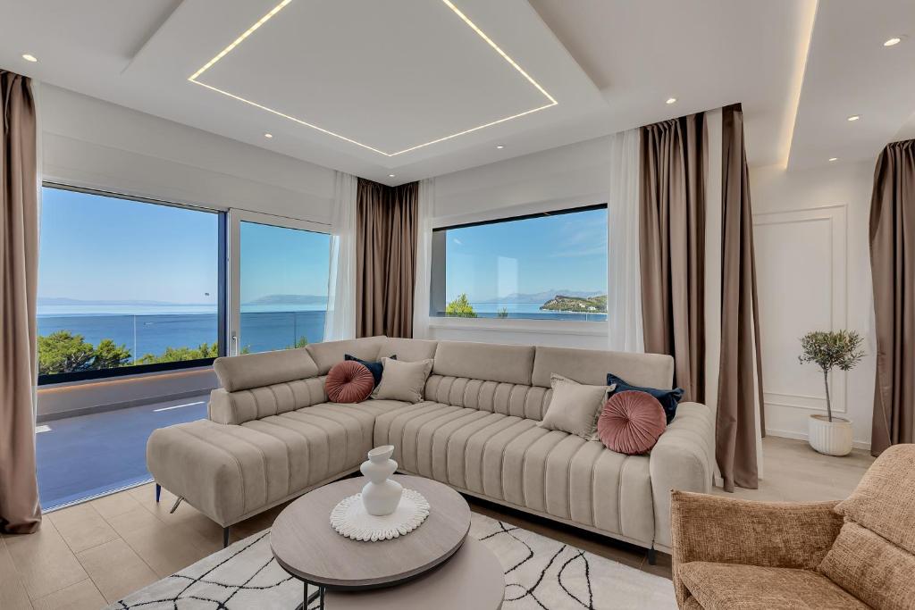 a living room with a couch and large windows at Blue Dream - La Luna Residence in Tučepi