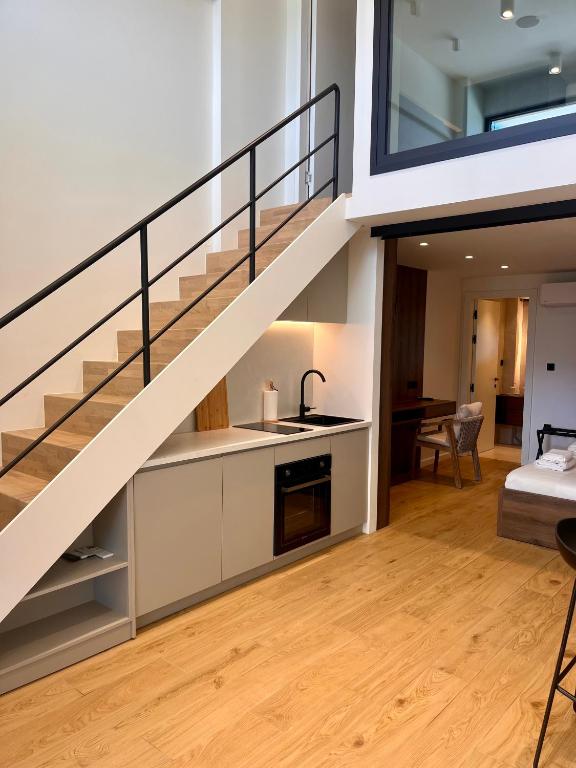 a kitchen and a living room with a staircase at Aeraki Apartments in Kavála