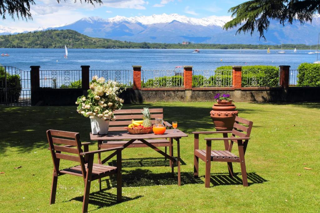 a wooden table with two chairs and a table with flowers at Il Giardino Sul Lago in Viverone