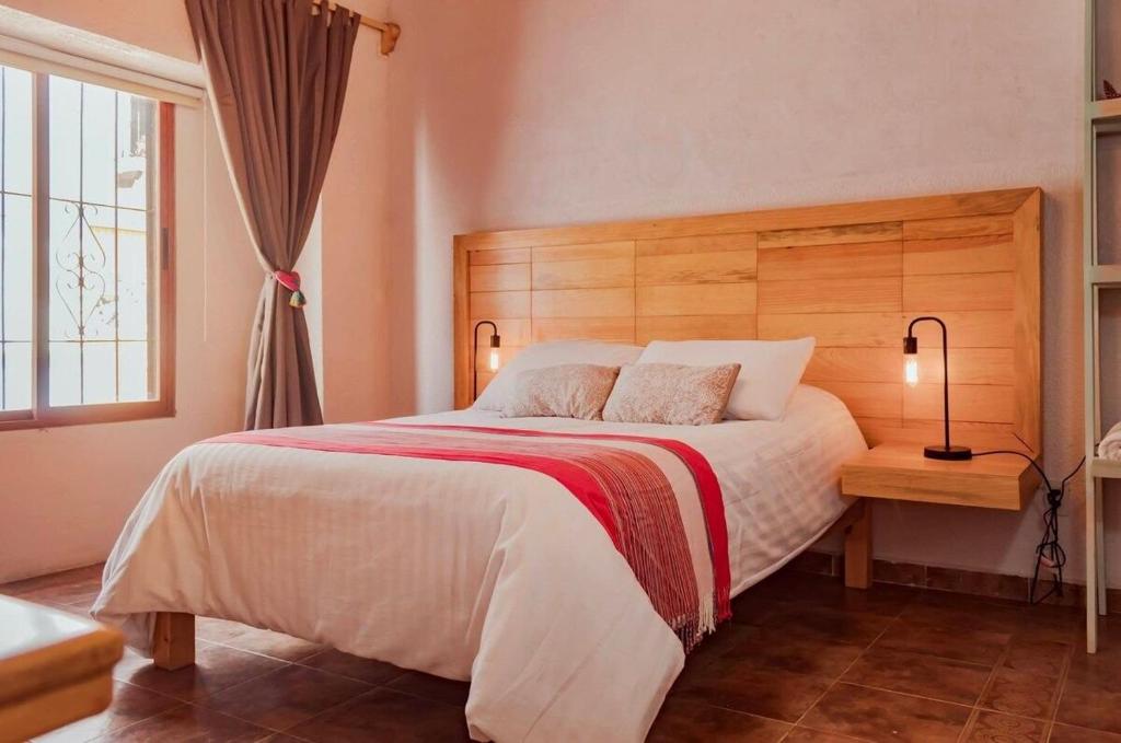 ein Schlafzimmer mit einem großen Bett mit einem hölzernen Kopfteil in der Unterkunft loft Diego en San Cristóbal de las Casas in San Cristóbal de las Casas