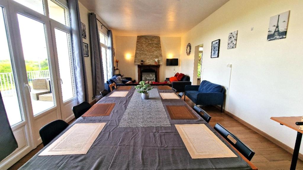 une longue table dans une pièce avec une cheminée dans l'établissement Appart 10personnes Terrasse vue Loire, Parkings Voitures Vélos,10min Centre Blois,40min Zoo Beauval, à Blois