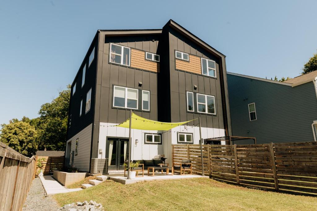 a black and white house with a fence at ModTrio 3BR with ensuites & Garage Mins to Uptown in Charlotte