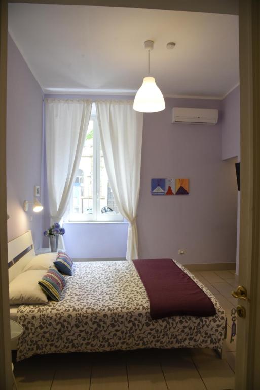 a bedroom with a bed with a window at Cerasella B&B in Naples