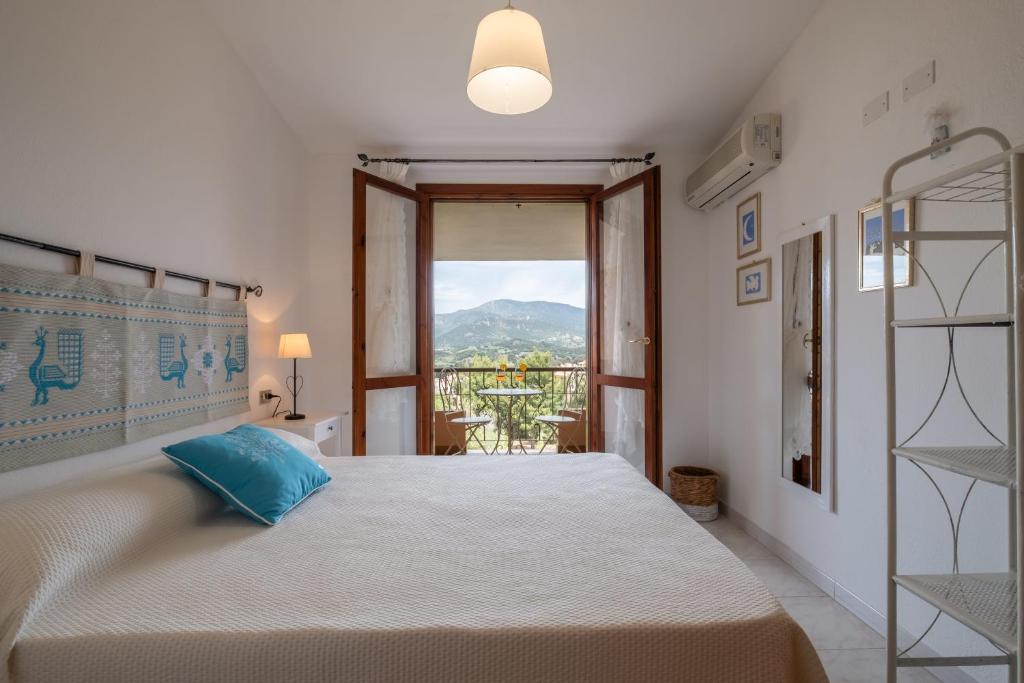 a bedroom with a large bed and a window at Design Villetta by Propertize in Villasimius