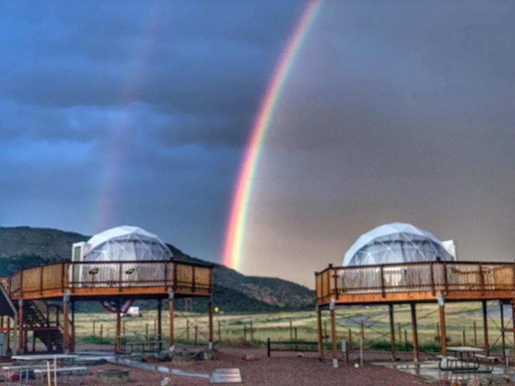 卡农城Mountain View RV Resort, Cabins & Glamping的两座穹顶上方的天空中出现了一道彩虹