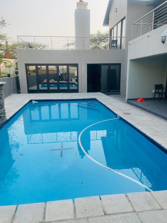 a large blue swimming pool in front of a house at Tan Ridge Hill in Vosburg