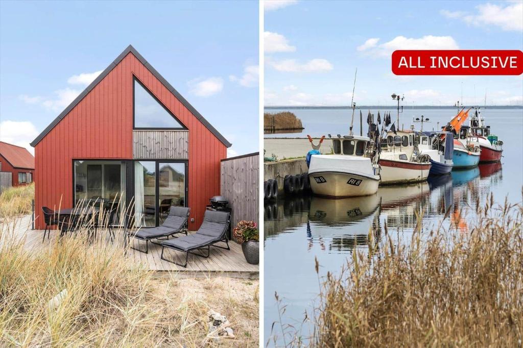 940-Hvide-Sande-Langsand-169 في فيد ساندي: مبنى أحمر مع كراسي وقوارب في الماء