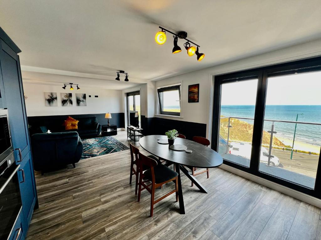 Una sala de estar con una mesa y vista al mar. en Penthouse North Sea Front, en Saltburn-by-the-Sea